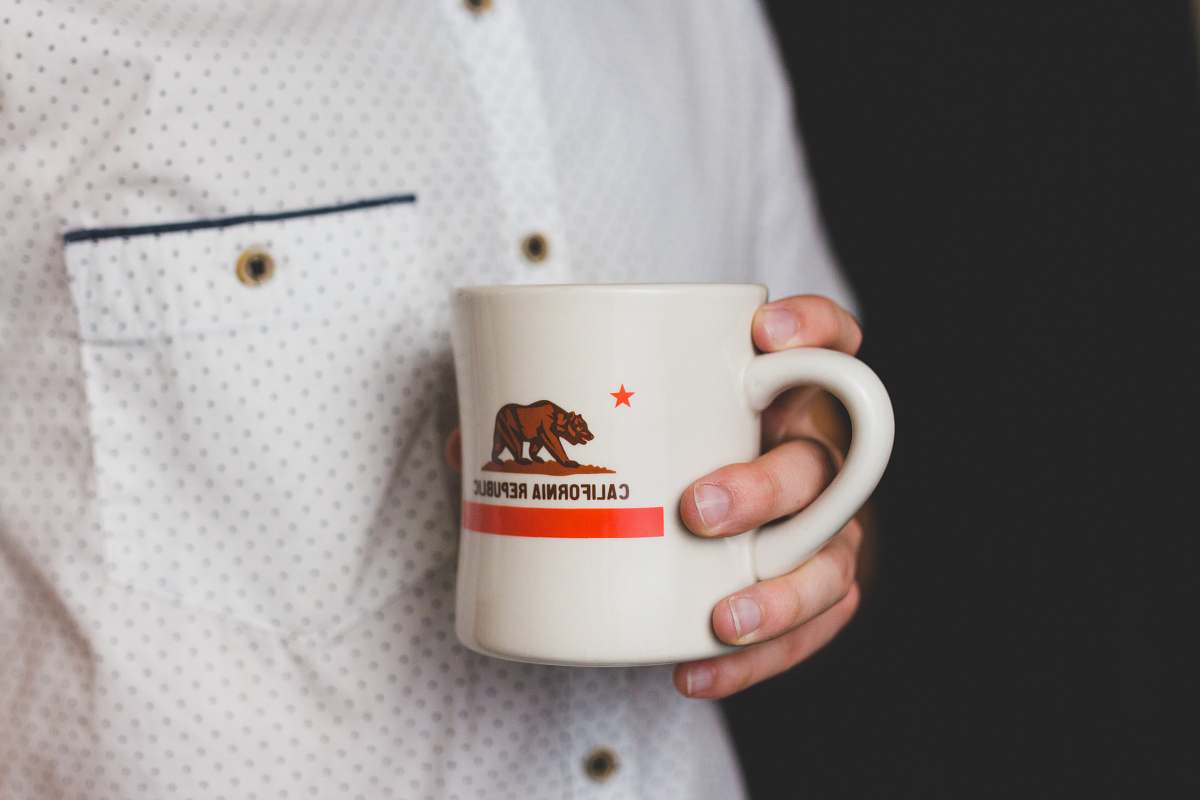 coffee cup person holding white and red California Republic ceramic mug california